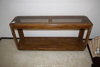 Full front view of the oak console table showing two glass top panels and bottom wood shelf.