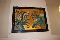 Four-panel decorative wall art screen mounted on the wall showing full artwork and frame.