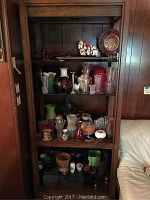 Front view of the wooden bookshelf filled with various decorative glass items for display purposes only, not included in the lot.