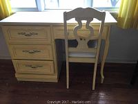 Desk and chair set placed against wall and window showing top and front views.