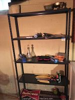Photo of the shelving unit with various items visible including glass decanter, stapler, aluminum foil box, and corn holders.