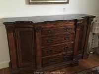 Front view of ornate breakfront showing overall design, cabinets, drawers and marble top