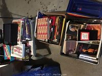 Lot overview showing crates filled with VHS tapes, books, and baseball cards.