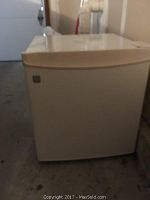 White GE mini refrigerator with closed door shown from the front.