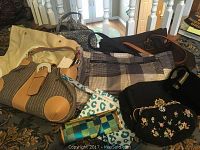Photo showing seven assorted ladies handbags in various sizes, patterns and materials on a table, highlighting vintage and modern styles.