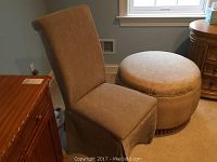 Side view of beige vanity chair with ottoman beside it, showing chair height and ottoman bulk