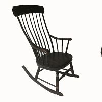 Side view of antique black painted wooden rocking chair showing curved armrest and rocker base.