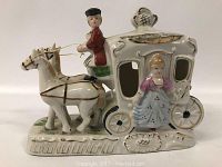 Front and side view of the porcelain horse and carriage figurine showing detailed painting and figures.