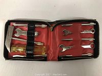 Photo showing tools inside the open zippered case including a hammer, screwdrivers, and wrenches on red lining.