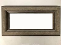 Rectangular mirror with weathered wood frame measuring approximately 12 by 6 inches