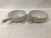 Two white round handle bowls side by side showing exterior and handle design.