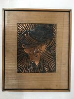 Front view of framed copper relief artwork depicting a woman in profile.