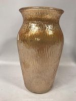 Front angled view of carnival glass vase showing its vertical rib texture and iridescent amber color.