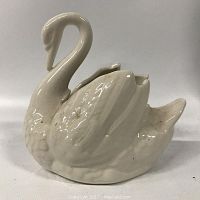 Side view of ceramic swan planter showing curved neck, wing, and feather details