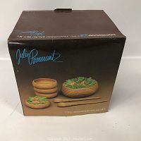 Photo of the product box showing the 7-piece teakwood salad set by Julie Pomerantz, featuring stacked bowls and serving utensils with a wood grain pattern.