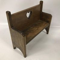 Right angled view of small wooden toy bench showing heart-shaped cutout in backrest, smooth finish, and sturdy construction