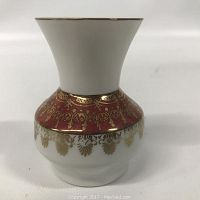 Photo showing front view of the small Pomerode porcelain vase with white top and red lower section accented by gold floral and heart patterns.