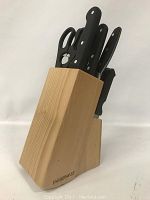 Front angle of wooden Farberware knife block filled with various knives and scissors.