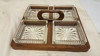 Front perspective photo of mid century rosewood divided service tray with four clear glass square dishes arranged in rows, each dish featuring a starburst cut pattern on the bottom.