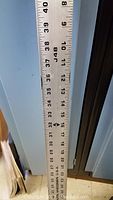 Close-up photo of the upper section of the aluminum ruler showing inch measurements from 10 to 40 approximately with detailed incremental markings.