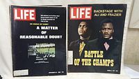Two vintage Life magazines stacked, one titled 'A Matter of Reasonable Doubt' on JFK assassination dated November 25, 1966, the other 'Battle of the Champs' featuring Ali and Frazier dated March 5, 1971.