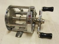 Side view of the Pflueger Rocket No. 1355 fishing reel showing the spool, frame, and handle grips.
