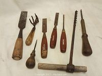 Photo showing eight vintage hand tools with wood handles spread out on white background for clear view of tool heads and handles.