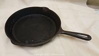 Used Findlay cast iron frying pan, 11 inch round, with handle and pour spouts visible, showing some surface wear.