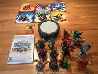 Top view showing Skylanders game case, portal, character figurines, and cards spread out on floor