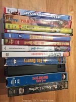 Stack of DVDs and VHS tapes showing titles such as Ice Age, Fast Trains, The Secret Garden, and others