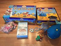Photo showing Cariboo board game, Jonah and the Whale bath toy whale blue figure, Little Polar Bear Lotto boxed game, assorted small toys and magnets on floor.