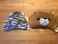 Front view of zebra and lion animal masks on a wooden floor