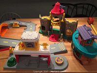 Wide view of the playsets on a table including castle, track, and building with loading platform
