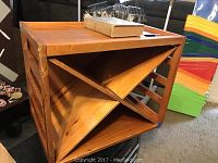 Light brown wooden wine rack with X-frame design for storing wine bottles