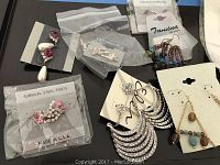 Initial display of various new fashion earrings on cards and in plastic bags