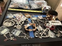 Overview photo showing all bracelets spread on a black surface including wooden bead, silver-tone chains, reversible cross charm bracelets, and tortoiseshell bangle.