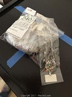 Plastic bag containing multiple Austrian crystal necklaces with silver-tone chains and crystal pendants, tagged and new in package.