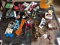 Overview of multiple jewelry items including bracelets, earrings, and necklaces laid on a glass table.