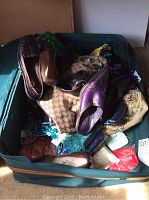 View of soft-sided suitcase filled with assorted purses and shoes.