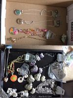 Photo showing various necklaces and earrings laid out in a box, displaying the colorful floral pendants and silver-tone earrings.