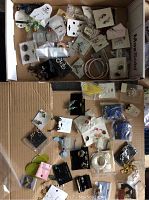 Box with assorted earrings, necklaces, and charms mostly in original packages and display cards