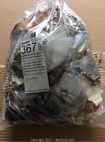Full view of sealed large plastic bag containing approximately 7 pounds of mixed jewelry pieces including necklaces, bracelets, and earrings.