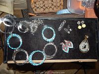 Top view of vintage turquoise look bracelets, earrings, and pendants on black velvet background