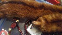 Photo of a brown vintage mink fur collar next to a beaded necklace