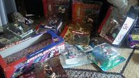 Collection of sports collectible figures displayed on floor, includes boxed and blister pack items from NHL and MLB.