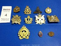 View of all 11 badges and pins placed on blue background, showing front details and variety of Canadian military emblems.