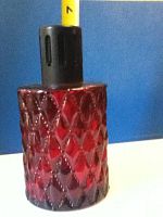 Close-up of the red glass air purifier's diamond patterned body with black burner cap.