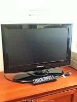 Front view of the Samsung 22-inch flat screen television with remote on the stand