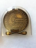 Front side of the medallion showing Newfoundland & Labrador Confederation Anniversary text with a wreath design, dated 1949-1989.