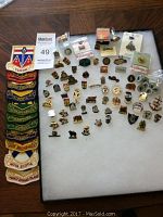 Full overview showing a combination of embroidered patches with Canadian province names and various metal enamel souvenir pins. Patches show bright colors with clear text. Pins show various crests and badges in gold-tone metal.